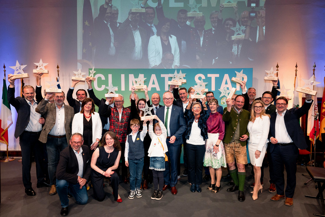 Personen auf einer Bühne mit den Climate Star Pokalen in der Hand.
