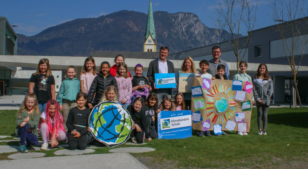 Kinder der VS Kundl bei feierlichen Klimabündnisbeitritt mit bunten Schildern und Plakaten