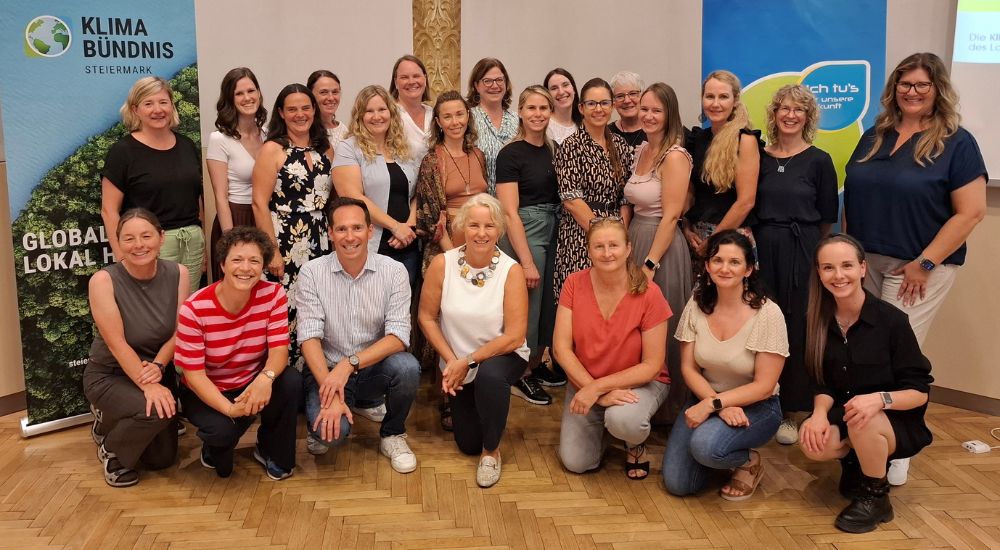 Gruppe von Menschen in drei Reihen lächeln in die Kamera