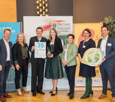 Klimabündnis Auszeichnungsgala: Gemeindevertreter stehen mit Vorständen vor dem Klimabündnis und Land Steiermark Rollup und lächeln. Sie halten die Auszeichnungen in den Händen.
