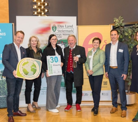 Klimabündnis Auszeichnungsgala: Gemeindevertreter stehen mit Vorständen vor dem Klimabündnis und Land Steiermark Rollup und lächeln. Sie halten die Auszeichnungen in den Händen.