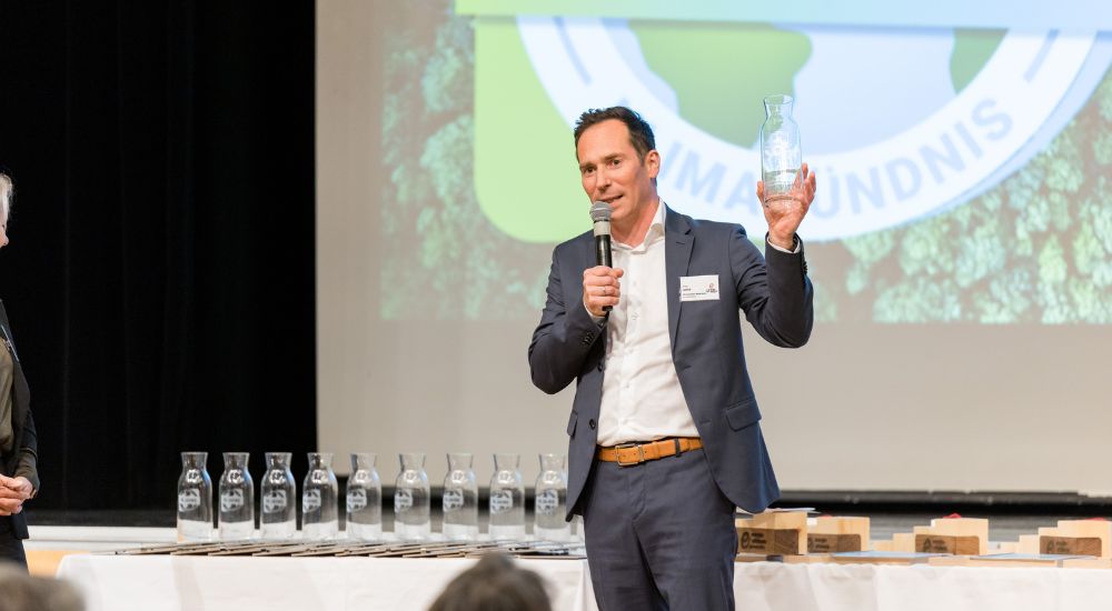 Friedrich Hofer (GF Klimabündnis Steiermark) präsentiert Glaskaraffe