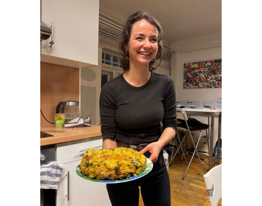 Frau mit Teller in der Hand, strahlt über das ganze Gesicht