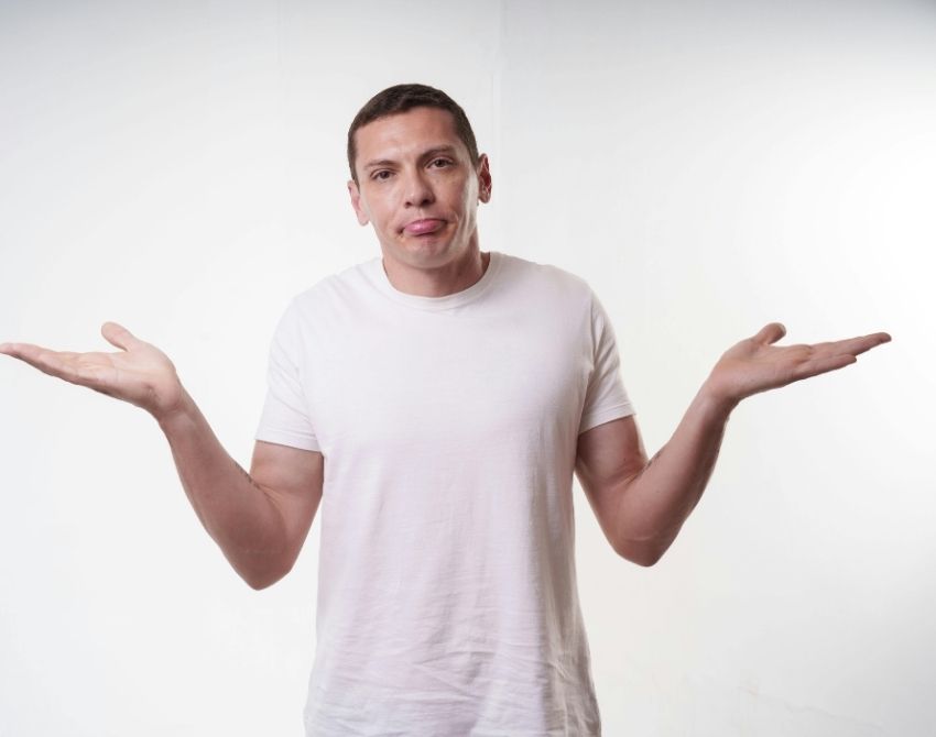 Mann hebt fragend Schultern