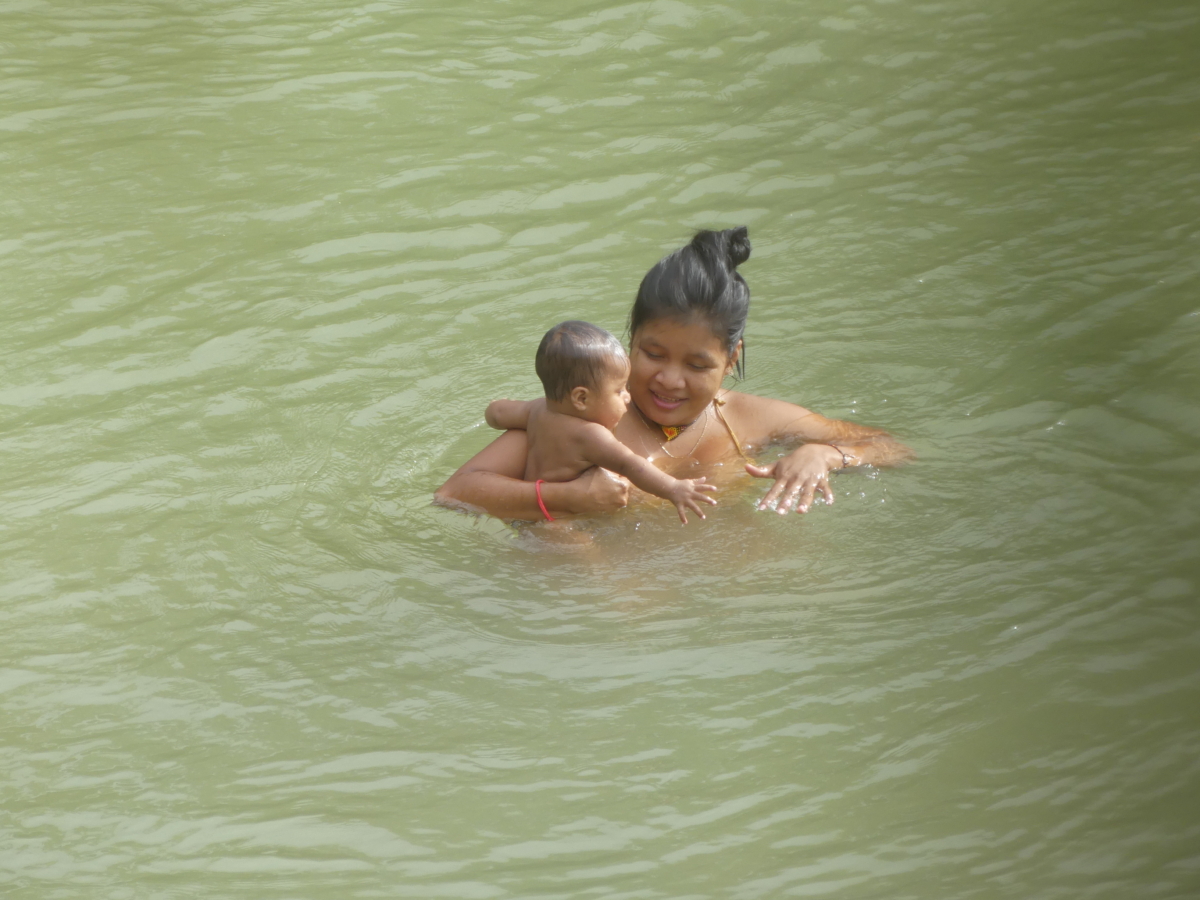Ein erfrischendes Bad für das Baby. Mutter und Kind vom Volk der Embera am Fluss Tutunendo. Chocó 2025