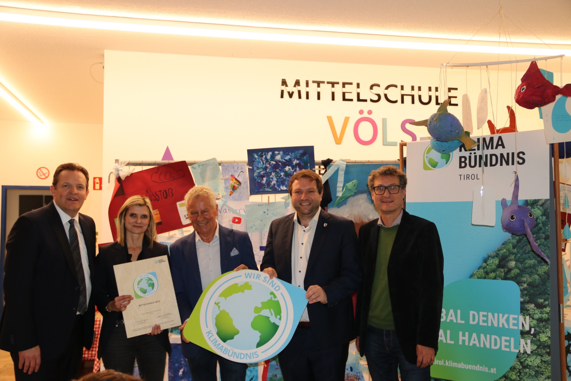 Vier Frauen und ein Man halten ein Schild und eine Urkunde des Klimabündnis